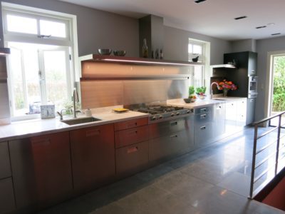 Luxe Arclinea keuken met RVS fronten, donker eiken accenten en een strak werkblad in een lichte ruimte.