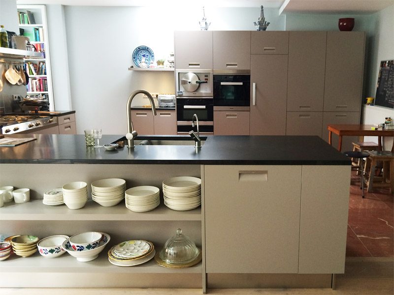 Titan ITALIA keuken met strak granieten werkblad en open keukeneiland met servies.
