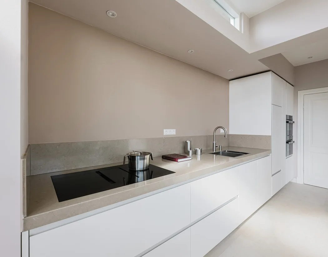 Strakke witte Cesar Maxima 2.2 keuken met een minimalistisch design en een elegant stenen werkblad.