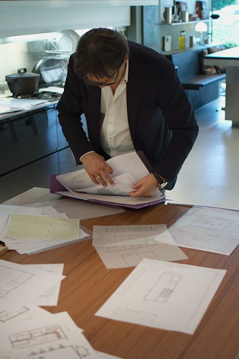 Ontwerper bekijkt technische tekeningen en schetsen voor een maatwerk interieurproject.